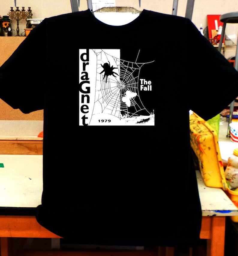 May include: Black t-shirt with a white graphic of a spider web, a spider, and the text "dragnet" and "The Fall" with the year "1979" below.