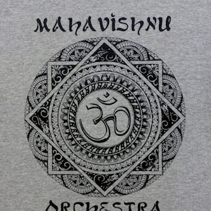 May include: A gray t-shirt with a black mandala design featuring the Om symbol and the text "MahaVishnu Orchestra".