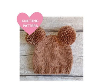 May include: A knitted brown beanie with two large pom-poms. The hat is made of a textured yarn and has a ribbed brim. A pink heart-shaped graphic with the words "KNITTING PATTERN" is in the upper left corner.