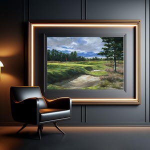 May include: A framed painting of a golf course with a green fairway, sand trap, and a red flag in the distance. The sky is cloudy and blue with a few white clouds. The painting is framed in a gold frame.