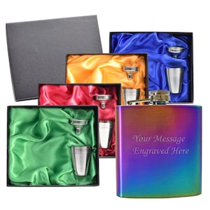 May include: A rainbow-coloured stainless steel hip flask with a funnel and shot glass. The flask has the text "Your Message Engraved Here" on the front. The flask is displayed in a box with a green satin lining.