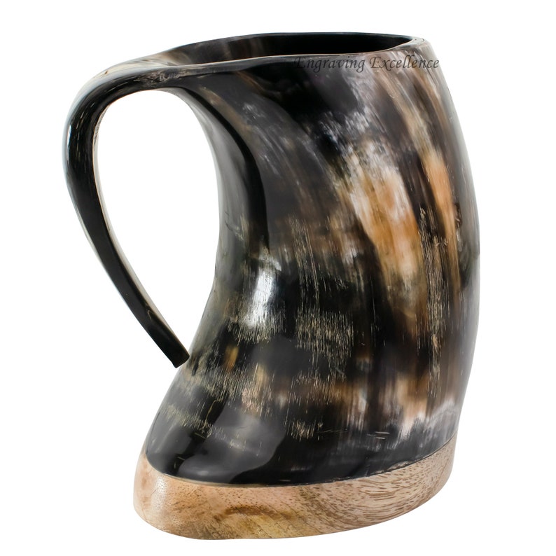 May include: A black and brown horn drinking mug with a wooden base. The mug has a unique shape and a large handle.