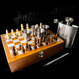 May include: A wooden chessboard game set with a personalised stainless steel hip flask engraved with "Phil's Whiskey". The set includes four shot glasses and a silver pen.