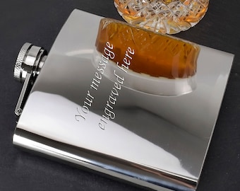 Puede incluir: Una petaca de plata con tapón de rosca. La petaca está grabada con el texto "Your message engraved here".