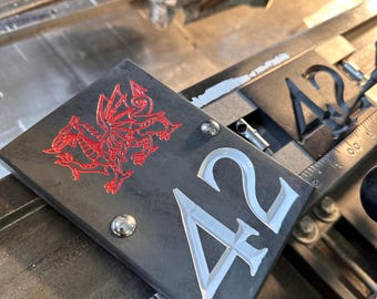 Letrero de pizarra con número de casa grabado: dragón galés, narcisos, trébol, cardo y rosa inglesa