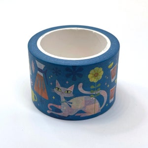 May include: A blue washi tape roll with a design featuring a cat, flowers, and a coffee pot. The cat is light pink and white with blue eyes. The flowers are yellow and orange. The coffee pot is brown and orange.