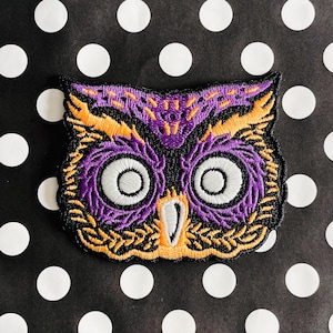 May include: Purple and orange embroidered owl patch with large white eyes.
