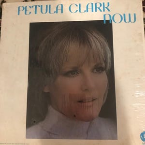 Peut inclure: Une pochette d'album vinyle blanche avec une photo de Petula Clark. Le titre de l'album est "Now" et est imprimé en grandes lettres blanches en gras.