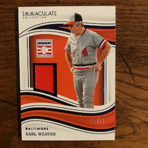 May include: A baseball card featuring Earl Weaver, a former manager of the Baltimore Orioles. The card is from the Immaculate Collection and features a red jersey patch. The card number is 08/15.