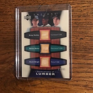 Könnte beinhalten: Eine Baseball-Sammelkarte in einer Schutzhülle. Die Karte zeigt drei Baseballspieler und den Text "TRILOGY" und "Generations of LUMBER". Die Karte hat das Upper Deck-Logo und Spielernamen.