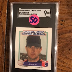Puede incluir: Tarjeta de béisbol de Nolan Ryan de la serie 1988 Parker Bros. Starting Lineup Talking Baseball All-Stars, en un protector. Una pegatina de precio rosa con el número 50 es visible.