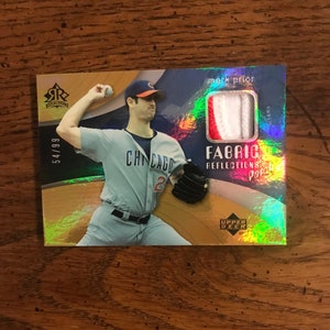 Könnte beinhalten: Baseballkarte mit Mark Prior von den Chicago Cubs. Die Karte hat einen Stoffaufnäher und den Text "Fabric Reflections Patch". Die Karte ist mit 54/99 nummeriert und hat einen holografischen Hintergrund.