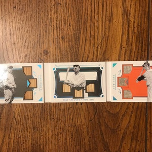 Puede incluir: Tres tarjetas de béisbol con una foto en blanco y negro de un jugador de béisbol con uniforme. Las tarjetas son blancas con detalles azules y naranjas. El texto en las tarjetas dice "Cincinnati", "Nueva York" y "Riley Thompson".