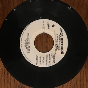 May include: A white vinyl record label with black text. The label is for a song called "When You Get A Little Lonely" by Nicolette Larson. The label is a promotion copy and is not for sale.