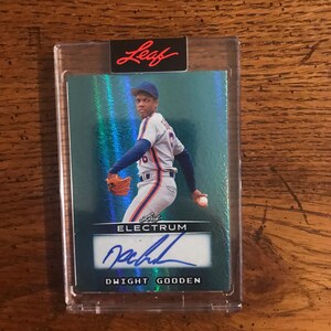 May include: A baseball card featuring Dwight Gooden in a New York Mets uniform, pitching. The card has a teal background with holographic effects and the Leaf Electrum logo. It is encased in a clear protective holder.