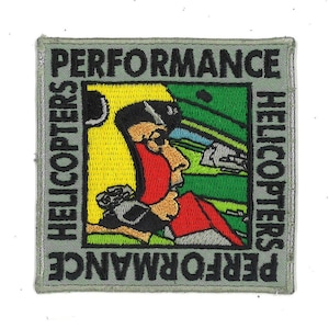 May include: A green, yellow, and red embroidered patch with a cartoon image of a pilot in a helicopter. The text "PERFORMANCE HELICOPTERS" is written around the image.