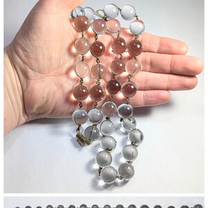 May include: A vintage glass bead necklace with alternating clear and light brown beads. The necklace is approximately 18 inches long and features a brass clasp.