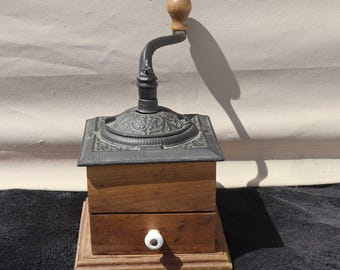 Molinillo de café antiguo de manivela, caja de madera, tapa de metal fundido, tirador de cajón de porcelana.