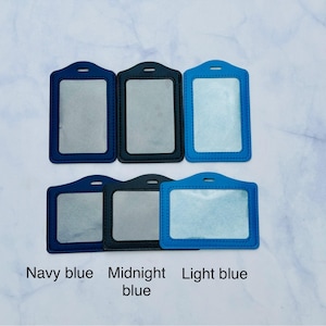 May include: Five different colored plastic badge holders. The holders are navy blue, midnight blue, and light blue.