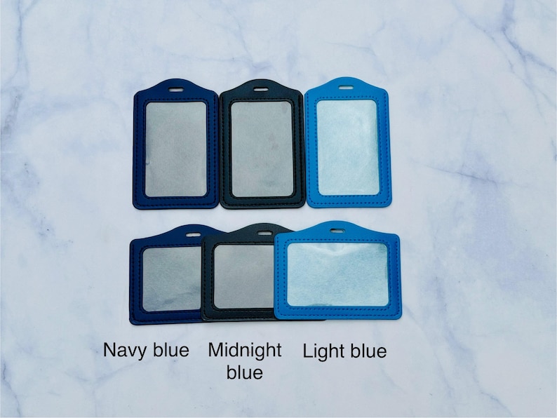 May include: Five different colored plastic badge holders. The holders are navy blue, midnight blue, and light blue.