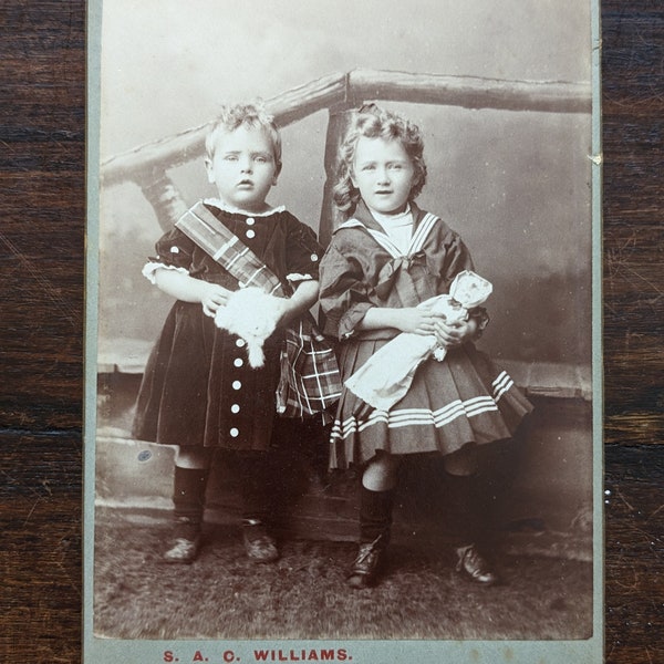 Antique cabinet card photograph of children with a doll