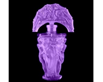 May include: A purple glass bottle with a decorative stopper featuring a group of figures. The bottle has a textured surface and a geometric base.