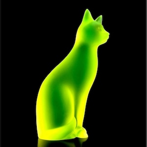 Puede incluir: Una figura de gato verde neón en posición sentada, con un diseño elegante y minimalista. La silueta del gato es suave y el degradado de color transita de un amarillo brillante en la base a un verde vibrante en la parte superior, sobre un fondo negro.