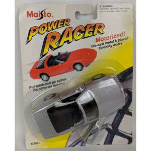 May include: Silver Maisto Power Racer die-cast metal and plastic toy car on a blister pack. The packaging features a red car graphic and the text "Motorized!" and "Pull-back-and-go action". The car has opening doors.