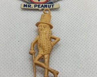 Two mr. peanut collectible items. pin and charm.