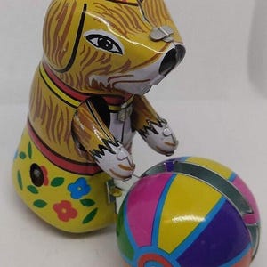 Puede incluir: Un juego de tres tazas de cerámica con un esmalte moteado de color crema. Cada taza presenta un diseño pintado a mano diferente: una hoja azul y verde, una flor amarilla y una baya roja. Las tazas tienen un diseño simple y moderno.