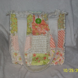 May include: A patchwork tote bag with a variety of floral and patterned fabrics in shades of peach, green, and white. The bag has white straps and a green button closure. The bag's design includes text from a book. The date 10/29/2020 is visible.