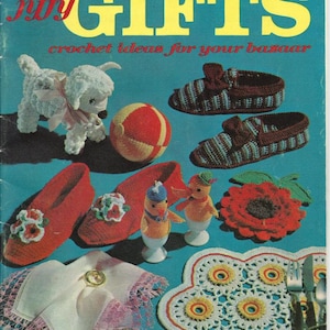 May include: A vintage crochet pattern book titled "Jiffy Gifts" with a blue cover and the text "crochet ideas for your bazaar". The cover features a variety of crocheted items, including slippers, a lamb, a ball, a flower, and a doily.