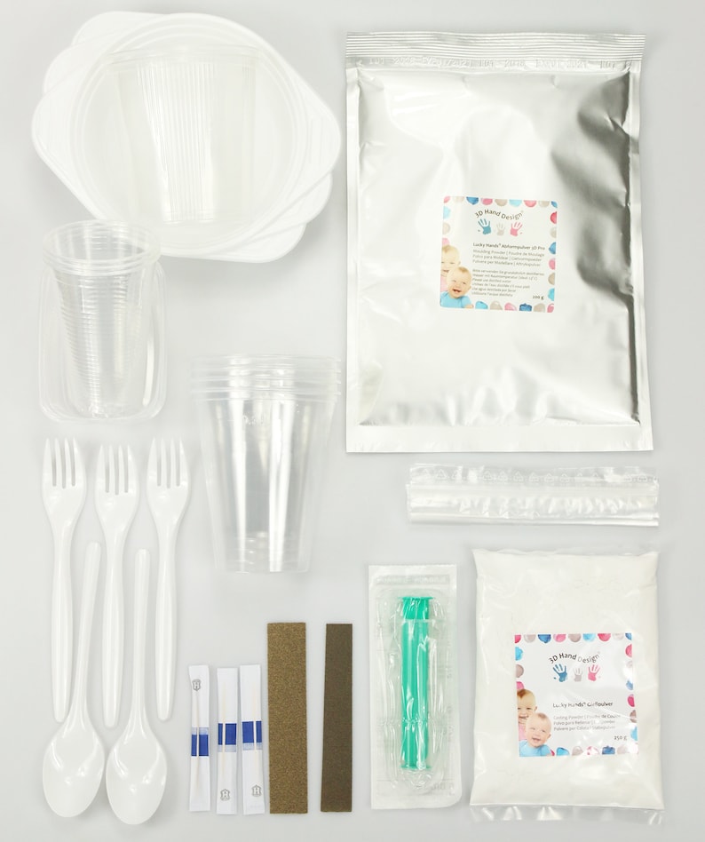 May include: A kit for making 3D hand casts with a white powder, a clear plastic syringe, two sanding blocks, three white plastic spoons, four white plastic forks, three clear plastic cups, three white plastic plates, and two packages of instructions. The kit includes the text "3D Hand-Cast Kit" and "Baby's First Hand-Cast"