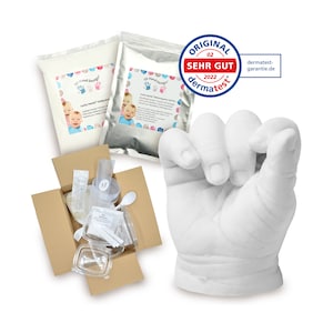 May include: A 3D hand casting kit with two bags of casting powder, a clear plastic container, a spoon, a syringe, and a white plaster hand cast. The kit is in a brown cardboard box. The box is open and the contents are visible. The kit is labeled "3D Hand Design" and "Lucky Hands - Handprint & Footprint Kit".