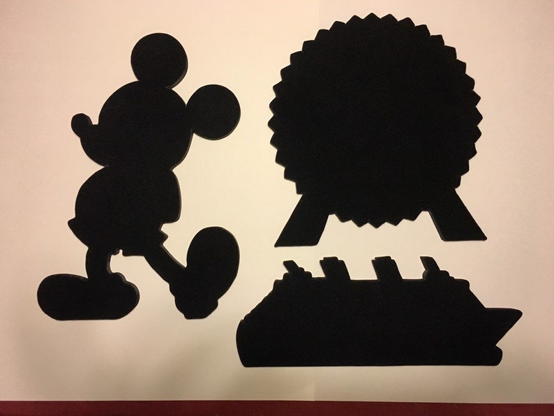May include: Black silhouette cutouts of Mickey Mouse, a cruise ship, and a Ferris wheel. The cutouts are on a white background.