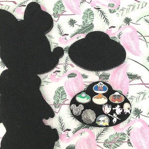 May include: Black felt pin display shaped like Mickey Mouse with a smaller, round display for pins. The round display has nine pins with various Disney characters and designs.
