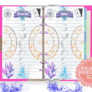 Puede incluir: Una agenda Filofax rosa de tamaño personal con un tema de luna y estrellas. La cubierta tiene un encuadernador de anillos plateado y una correa de cuero marrón. Las páginas están forradas y tienen un diseño de luna y estrellas. La agenda tiene una sección de lista de tareas y notas.