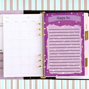 Puede incluir: Una agenda morada con detalles dorados y una p&aacute;gina que dice "Happy for..." con puntos y l&iacute;neas doradas.