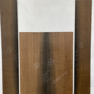 May include: Three pieces of wood veneer, two are long and narrow, one is wider and shorter. The wood is a dark brown with a light brown grain. The pieces are labeled with numbers.