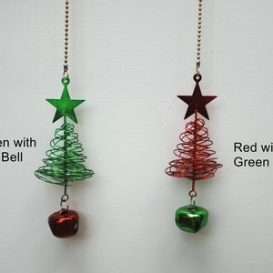 May include: Two Christmas tree ornaments. One is green with a red bell, the other is red with a green bell. Each ornament has a star at the top and a bell at the bottom. The text on the image says "Green with Red Bell" and "Red with Green Bell".