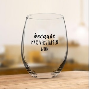 May include: A clear glass wine glass with the text "because Max Verstappen won" printed on it.