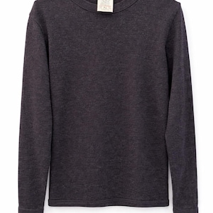 Puede incluir: Camiseta de manga larga gris carbón oscuro con cuello redondo. La camiseta tiene una etiqueta en el cuello. La tela parece ser un material de punto suave. Las mangas son largas y el dobladillo es recto.