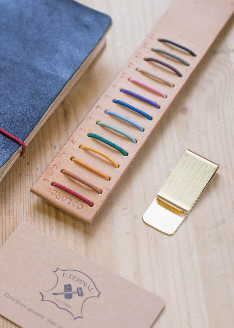 A selection of colorful elastic bands and a brass clip