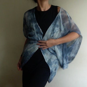 Peut inclure: Un cardigan bleu et blanc tie-dye avec une coupe ample et fluide. Le cardigan est fait d'un tissu léger et a un col en V.