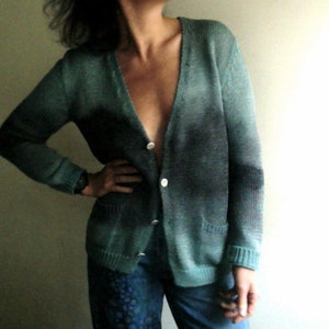 Peut inclure: Un cardigan en tricot bleu sarcelle et gris avec un col en V et une fermeture à boutons.