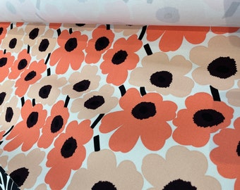May include: Close-up of a fabric with a repeating pattern of large, stylized flowers. The flowers are a light peach color with black centers and are set against a white background.