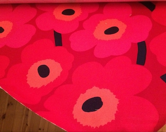 Puede incluir: Primer plano de una tela roja con un gran estampado floral. Las flores son en tonos de rojo y rosa, con centros naranjas y detalles negros. La tela es adecuada para la decoración del hogar o la moda.
