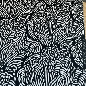 May include: Black and white fabric with a repeating pattern of abstract shapes. The fabric has the text "PENTIK JAKALA" printed on the side.