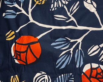 Puede incluir: Una tela azul marino con un patrón floral blanco. Las flores son rojas, amarillas y azules. La tela tiene una superficie texturizada.