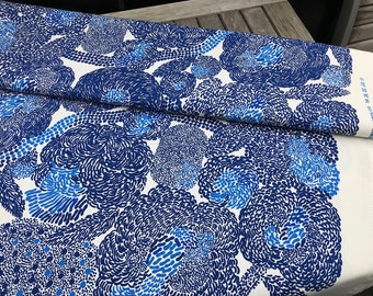 May include: White fabric with a blue and white abstract pattern of swirling circles. The fabric is folded in half and the text "SENYA cent. - R1819" is visible on the bottom right corner.